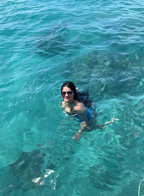 mulher jovem de oculos escuro e colete salva vidas azul mergulhando em mar aberto